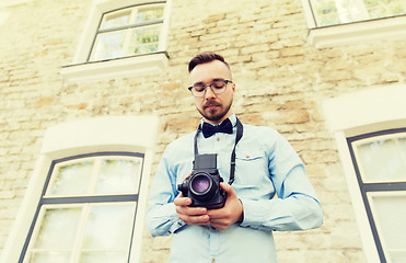 Image showing happy young hipster man with film camera in city