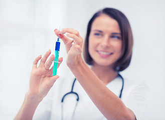 Image showing female doctor holding syringe with injection