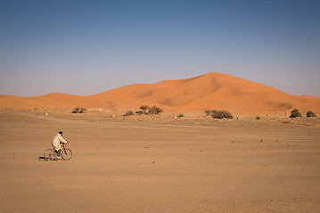 Image showing Man riding on a bike in Hassilabied, desert village in Morocco.