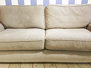 Image showing Beige sofa near the wall with striped wallpaper