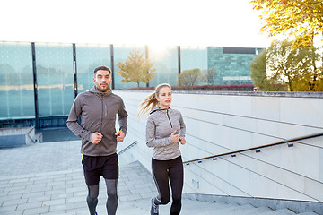 Image showing happy couple running upstairs on city stairs