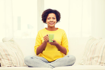 Image showing happy african american woman drinking from tea cup