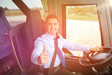 Image showing happy driver driving bus and snowing thumbs up