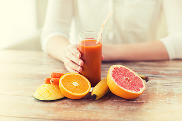 Image showing close up of woman hands with juice and fruits