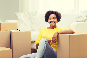 Image showing happy african woman with cardboard boxes at home