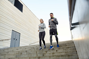 Image showing happy couple running downstairs in city