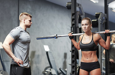 Image showing man and woman with barbell flexing muscles in gym