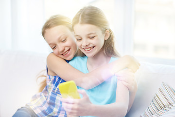 Image showing happy girls with smartphone taking selfie at home