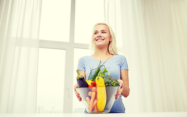 Image showing smiling young woman cooking vegetables at home