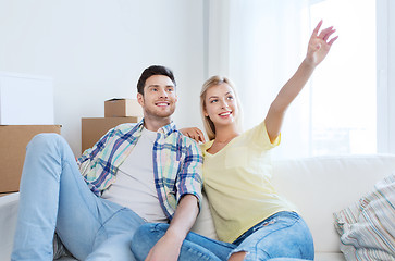 Image showing couple with boxes moving to new home and dreaming