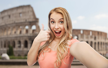 Image showing happy woman taking selfie and showing thumbs up