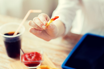 Image showing close up of woman hand holding french fries