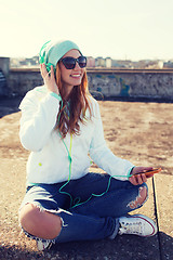 Image showing happy young woman with smartphone and headphones