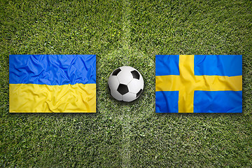 Image showing Ukraine vs. Sweden flags on soccer field