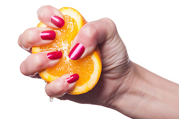 Image showing Hand with manicured nails touch an orange on white