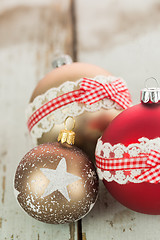 Image showing Three Christmas baubles on rustic wood