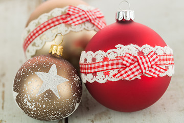 Image showing Three Christmas baubles on rustic wood