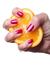 Image showing Hand with manicured nails touch an orange on white