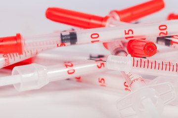 Image showing Pile of Empty Syringes with Red Safety Caps