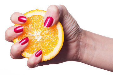 Image showing Hand with manicured nails touch an orange on white