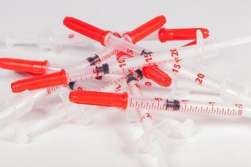 Image showing Pile of Empty Syringes with Red Safety Caps