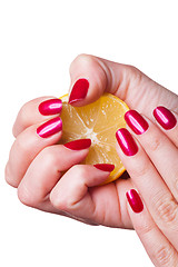 Image showing Hand with manicured nails squeeze lemon on white