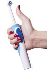 Image showing Hand holds electric toothbrush against white