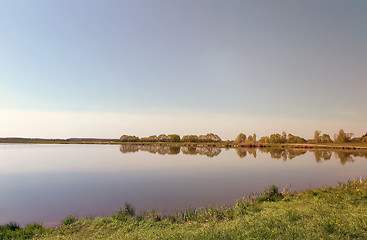 Image showing A large beautiful lake, with banks overgrown with reeds.