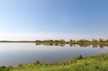 Image showing A large beautiful lake, with banks overgrown with reeds.