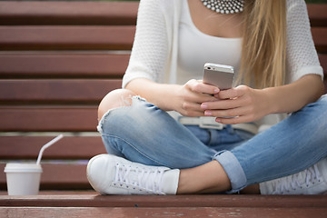 Image showing smart professional woman reading using phone. Female businesswoman reading news or texting sms on smartphone while drinking coffee on break from work. 