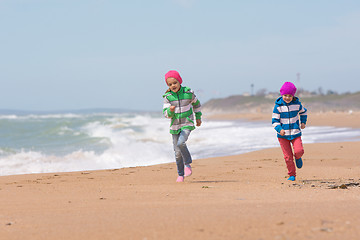 Image showing Two girls running on the beach seaside