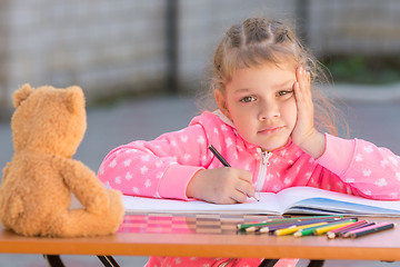 Image showing The girl does not know how to continue to draw drawing pencils