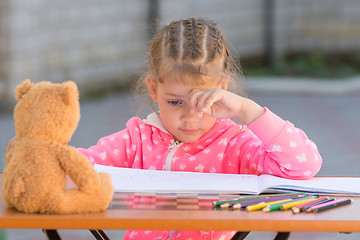 Image showing The girl does not know how to continue to draw drawing pencils