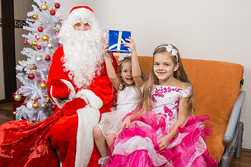 Image showing Santa Claus presented the first gift girls