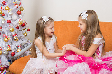 Image showing Two girls in beautiful dresses waiting Gift joined hands