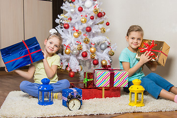 Image showing Two little girls with Christmas presents early in the morning sitting by the Christmas tree