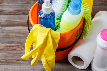 Image showing Plastic bucket with cleaning supplies on wood background