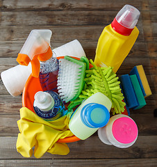 Image showing Plastic bucket with cleaning supplies on wood background