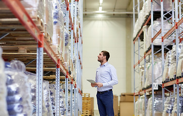 Image showing happy businessman with tablet pc at warehouse