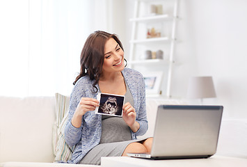 Image showing pregnant woman with ultrasound image and laptop