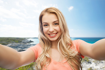 Image showing happy smiling young woman taking selfie