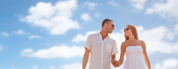 Image showing happy smiling couple walking over blue sky