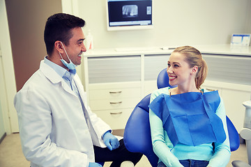 Image showing happy male dentist with woman patient at clinic