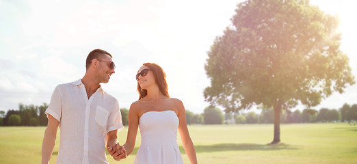 Image showing happy smiling couple walking over summer park