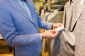 Image showing close up of man choosing clothes in clothing store