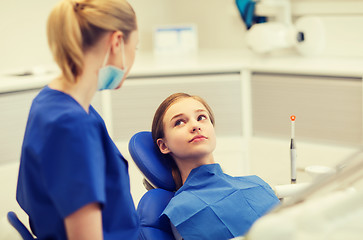 Image showing happy female dentist with patient girl at clinic