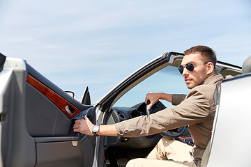 Image showing happy man opening door of cabriolet car outdoors