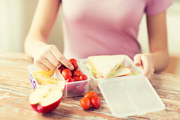 Image showing close up of woman with food in plastic container