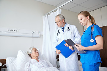 Image showing doctor and nurse visiting senior woman at hospital