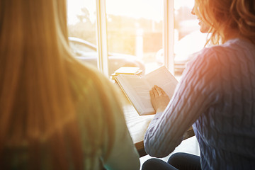 Image showing happy student girls reading book in library